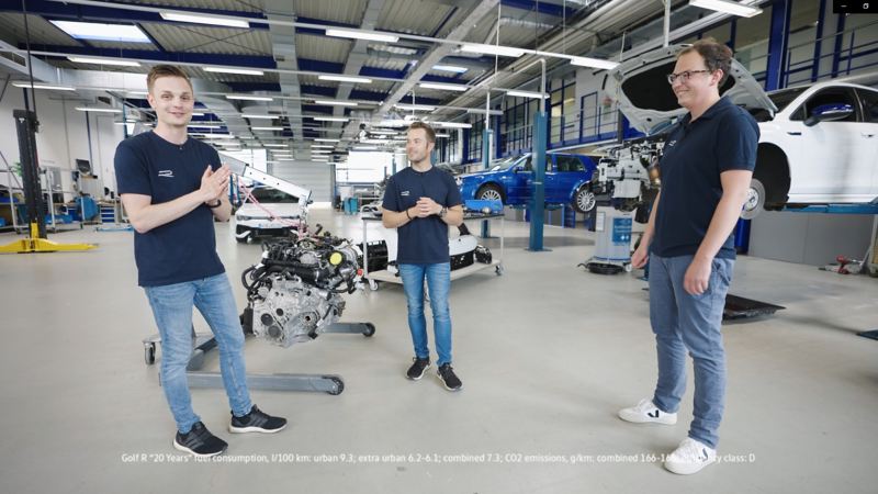 Drei VW R-Mitarbeiter stehen in einer Werkstatt mit mehreren VW Golf R „20 Years“
