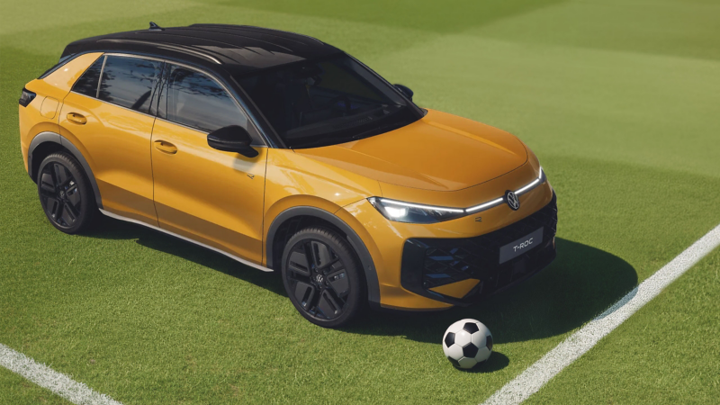 VW T-Roc R-Line steht auf Fußballplatz, vor dem Auto liegt ein Fußball