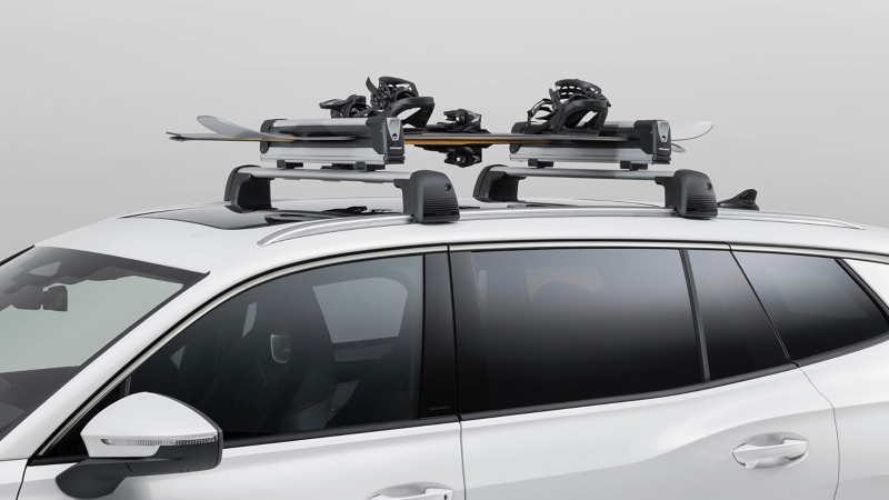 VW Tayron με ένα ζευγάρι σκι και ένα snowboard στην οροφή – βάση σκι και snowboard από τα Αξεσουάρ VW