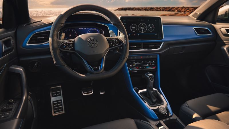 Vista della plancia di Nuovo Volkswagen T-Roc R, col pulsante R sul volante e il sistema di infotainment.