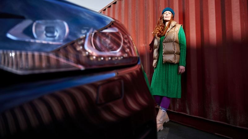 Detailaufnahme eines Scheinwerfers eines VW Touareg 2, im Hintergrund steht eine Frau