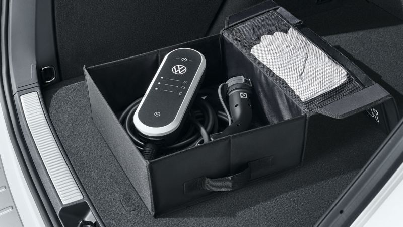 Boîte pliante pour câbles de recharge des accessoires VW ouverte – les gants, le câble de recharge et le chiffon de nettoyage sont visibles