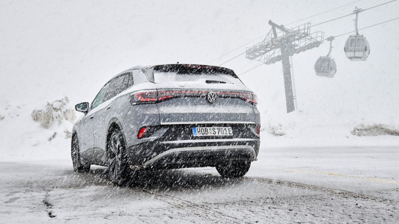VW ID.4 im Schnee, im Hintergrund eine Seilbahn