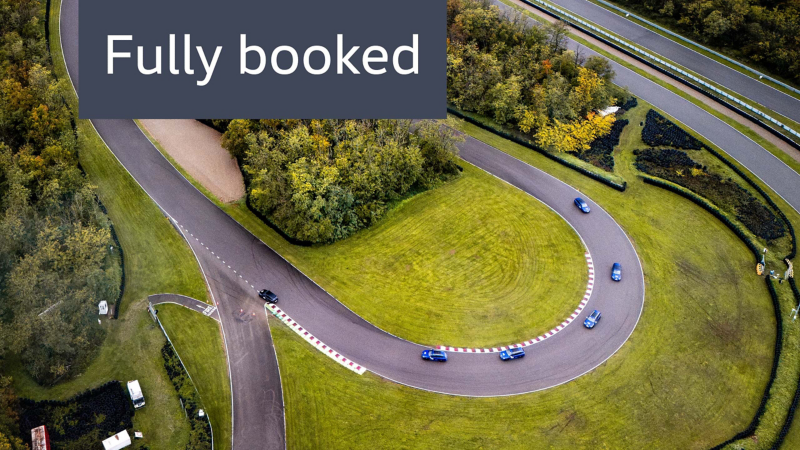 Aerial view of Driving Experience training vehicles taking a curve on race track