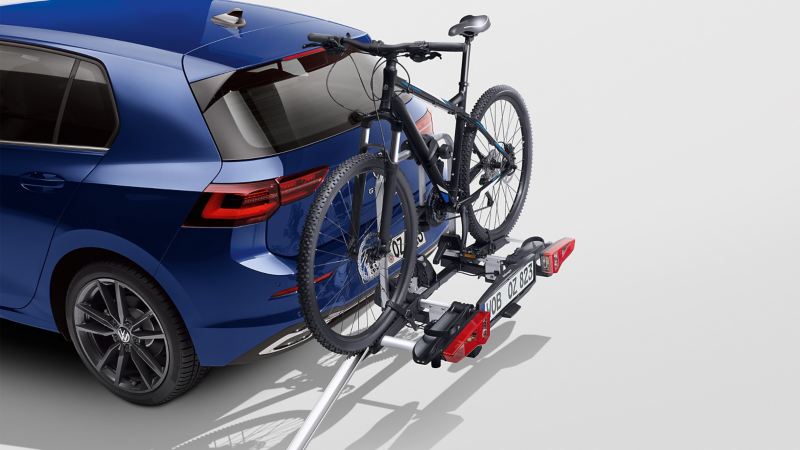 Een fietsendrager en oprijgoot van VW-accessoires op een blauwe VW Golf