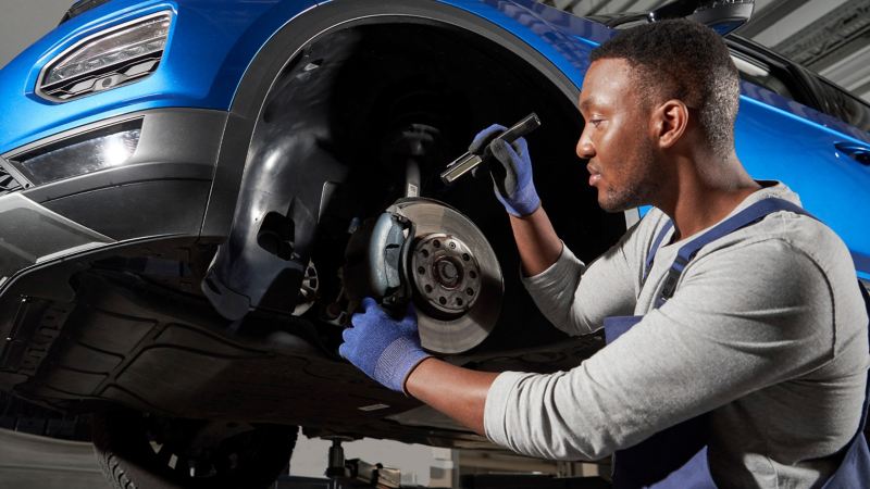 Ein VW Servicemitarbeiter beim VW Reifenwechsel in der Werkstatt