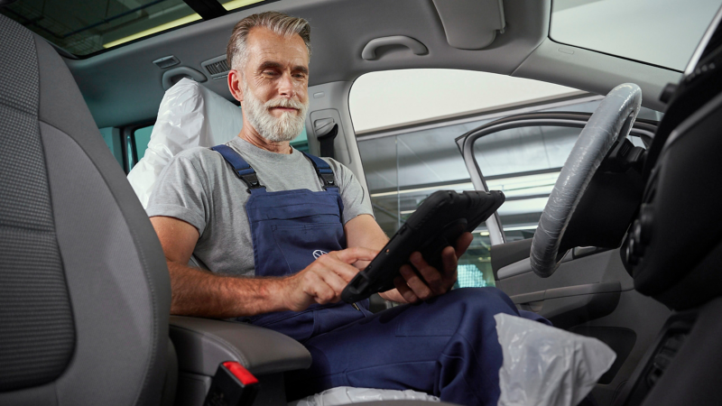 VW service employee with tablet in a VW car