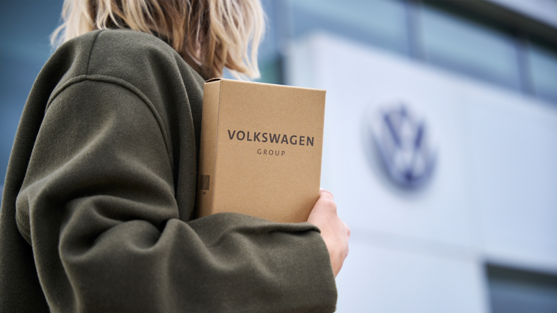 Woman holding a small package with Genuine VW parts