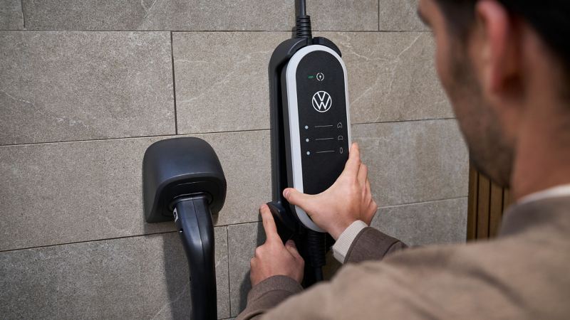 Man fixates wall mount set of ID. Charger Travel Basic on the wall