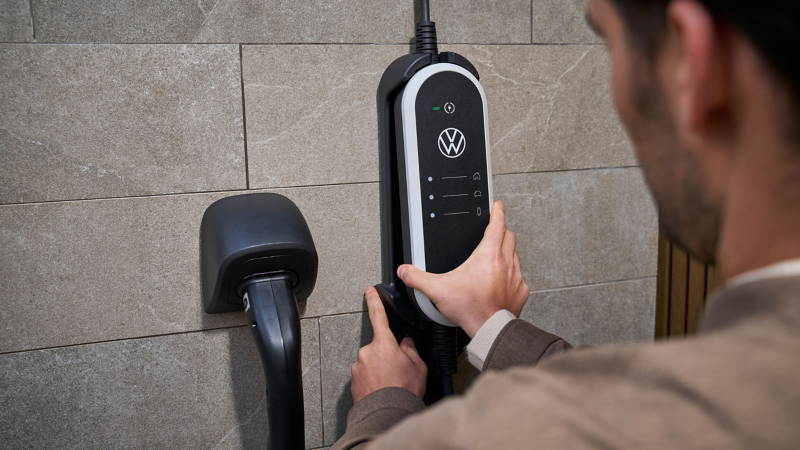 El hombre fija el soporte de pared conjunto de ID. Charger Travel Basic en la pared