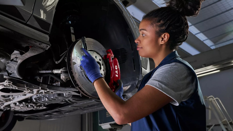 Volkswagen monteur bekijkt een remschijf in de werkplaats