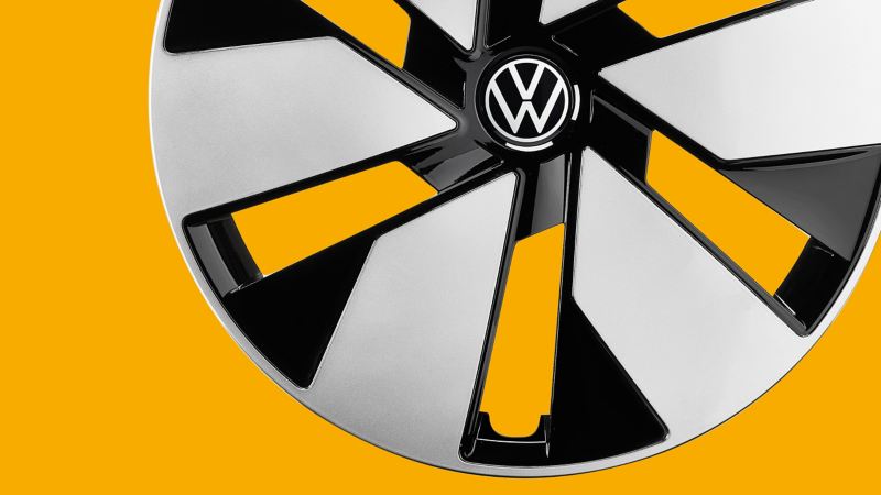 A VW wheel cover against a yellow background