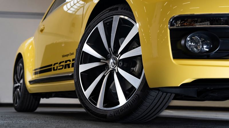 Detailed view of the wheel of a Beetle with polished rims – Volkswagen Accessories