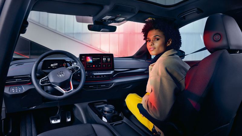 A woman sits in the passenger seat of a VW ID.