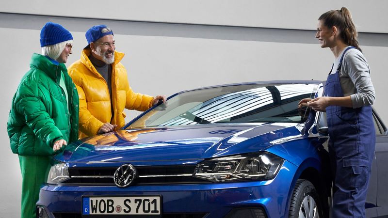 Μια υπάλληλος service σε συνεννόηση με δύο πελάτες σε ένα μπλε VW Polo 6  – Υπηρεσία επισκευής κρυστάλλων