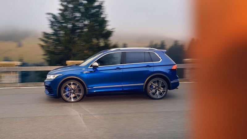 The VW Tiguan R in blue drives on a road