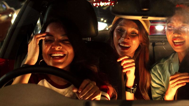 Die beiden jungen Frauen fahren mit ihren Freundinnen in ihrem roten VW Beetle