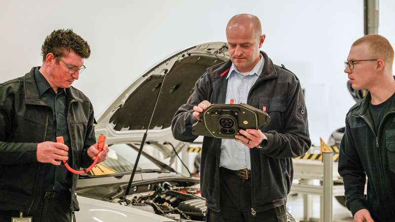 Drei Männer bei einer Schulung rund um Elektromobilität