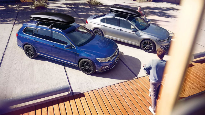 Deux voitures VW avec des coffres de toit se garent l'une à côté de l'autre – Accessoires Volkswagen.