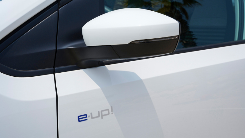 Zbliżenie na VW e-up! z widocznym logo.