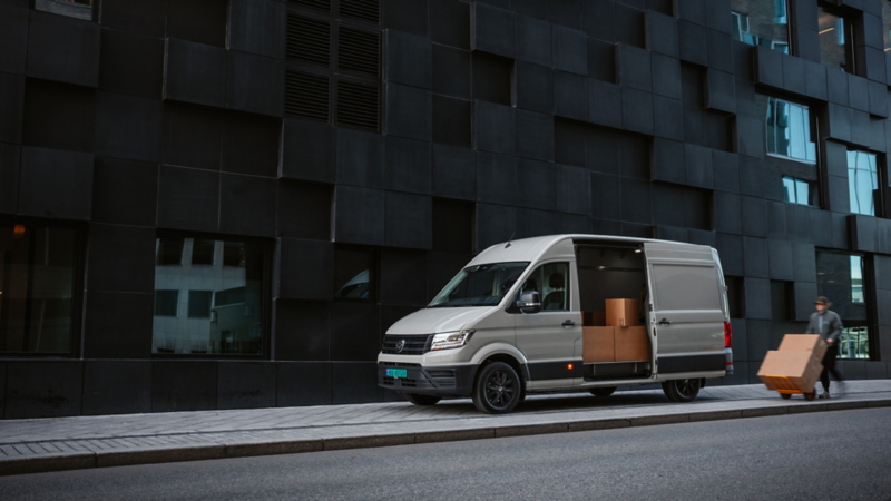 En person står foran en vw varebil og holder en hjertestarter fra lhl