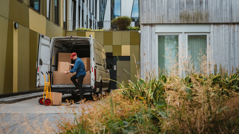 En mann laster varerommet i vw crafter varebil med paller