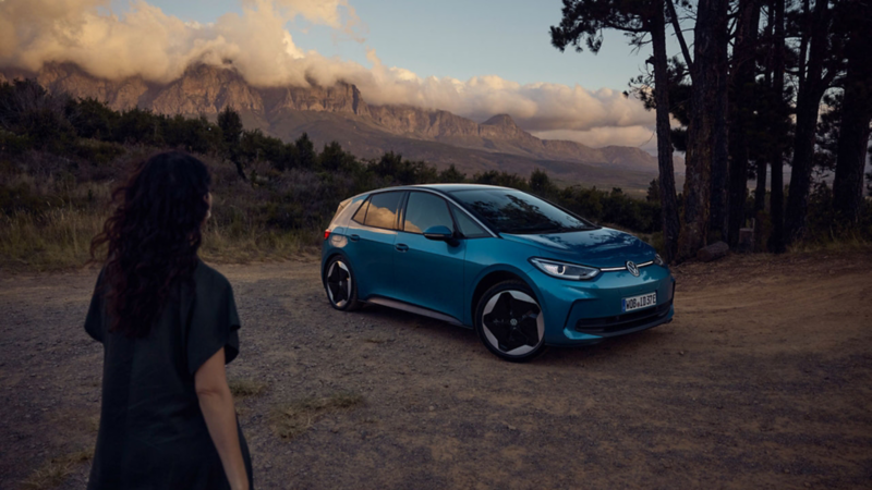 en kvinne går mot vw id3 kompaktil sett skrått forfra
