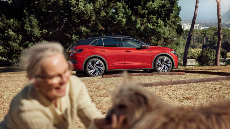 vw id4 suv sett bak en person og hund