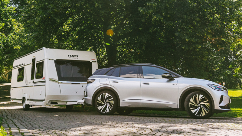 vw id4 sett fra siden med en stor bobilhenger tilkoblet