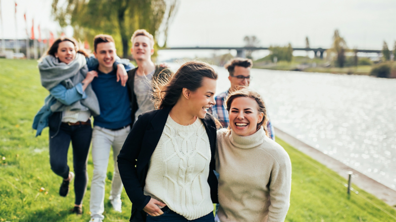 A group of young people walking along by the water in the Volkswagen car city Wolfburg
