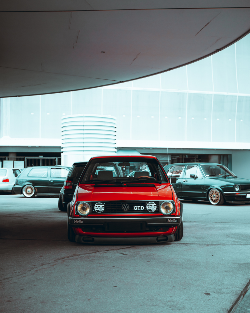 Czerwony Volkswagen zaparkowany na parkingu.