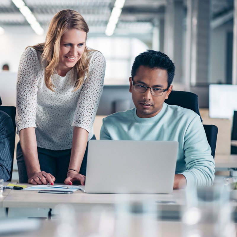 Three colleagues working together at a desk