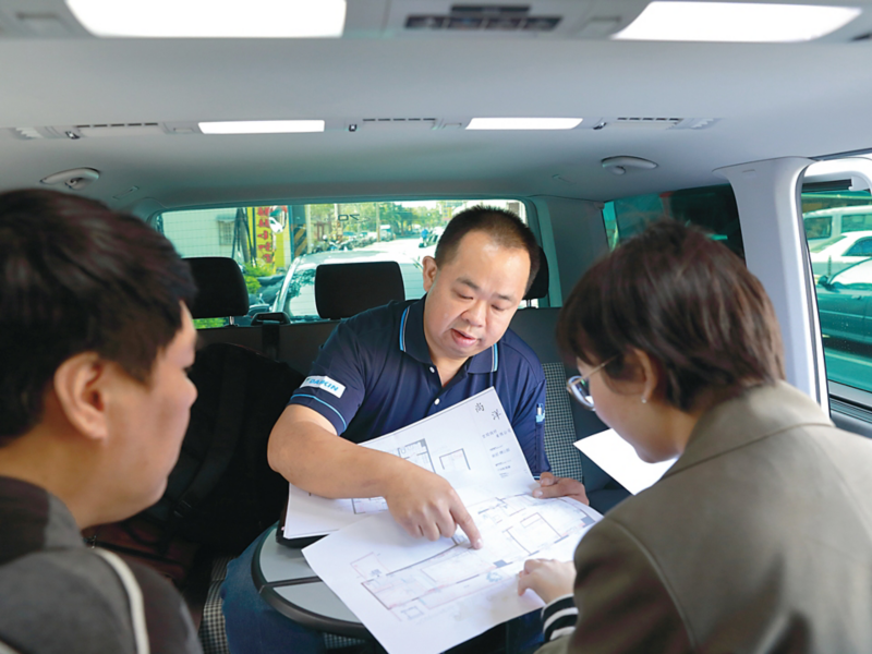 車主陳宏祥坐在Multivans車內，運用車內的小圓桌和客戶討論