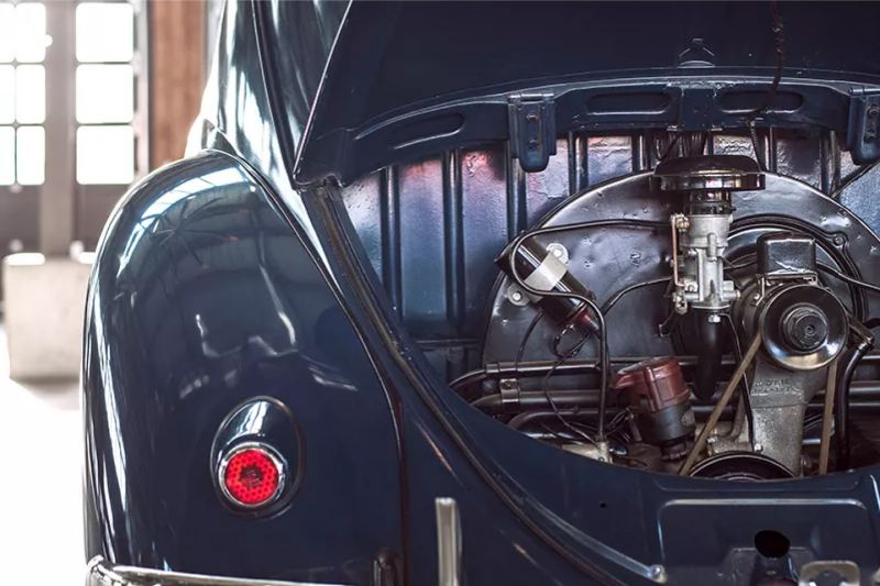 Escarabajo VW tradicional con el maletero abierto para mostrar el motor.