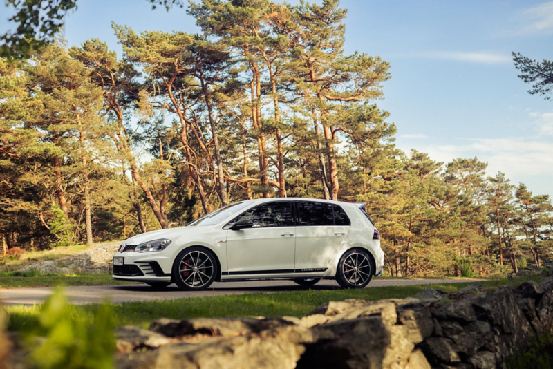 Emilas vita VW Golf GTI kör längs en väg kantad av skog