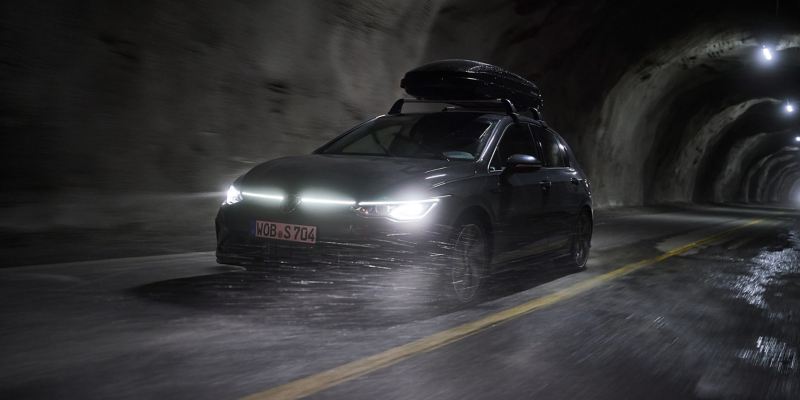 A VW Golf with glowing headlights in a tunnel