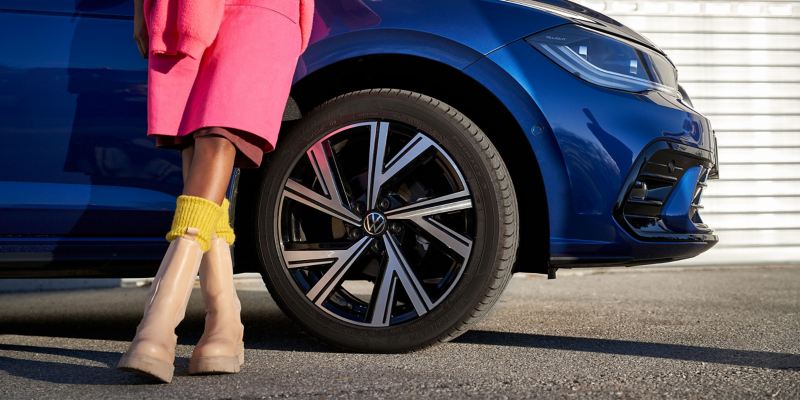 A woman walks towards her VW Polo with accessories rims