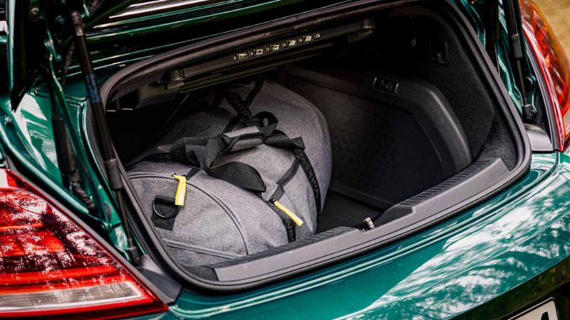 Dettaglio del vano portabagagli aperto di un'auto Volkswagen con dentro un borsone da viaggio.
