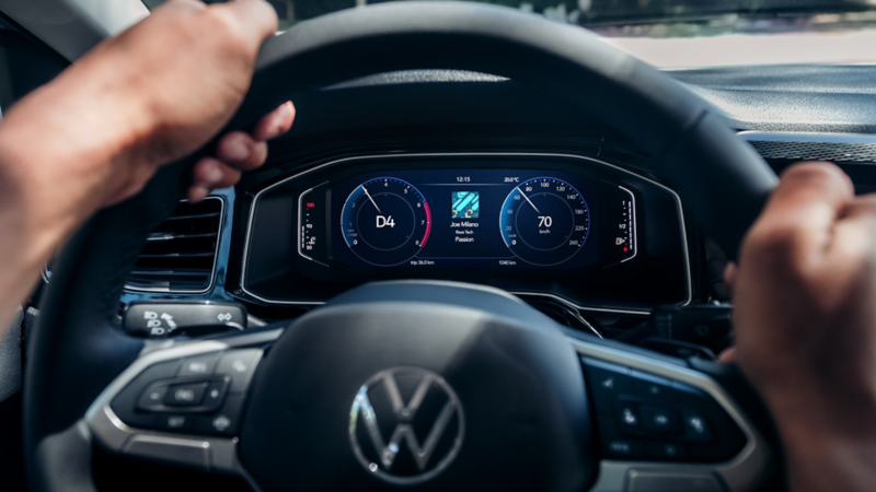 Conductor sujetando el volante del Volkswagen Polo con el panel digital activo.