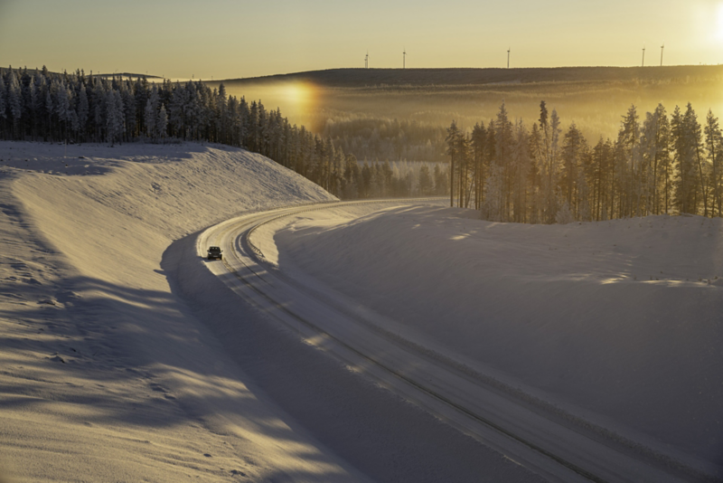 En grå ID.4 fotad med drönare i solnedgång på vinterväg i Malå.