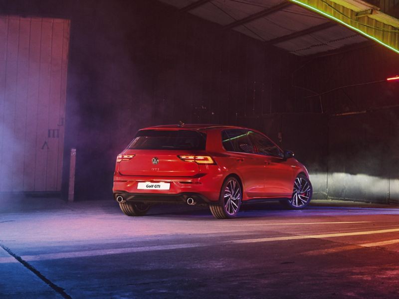 VW Golf GTI in red, rearview, parked in a warehouse