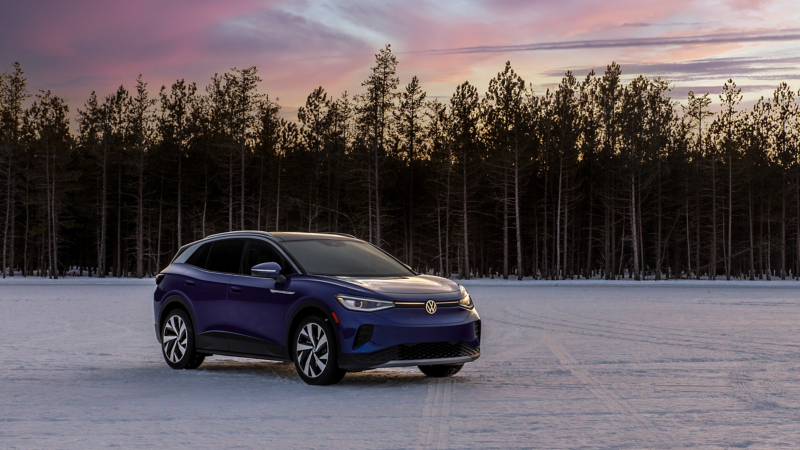 Front, medium-angled shot of an ID.4 SUV shown on a snowy lot surrounded by trees in the background.