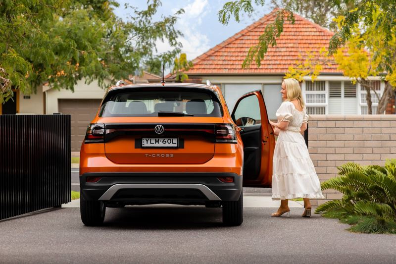 Woman opening the door of a Volkswagen T-Cross