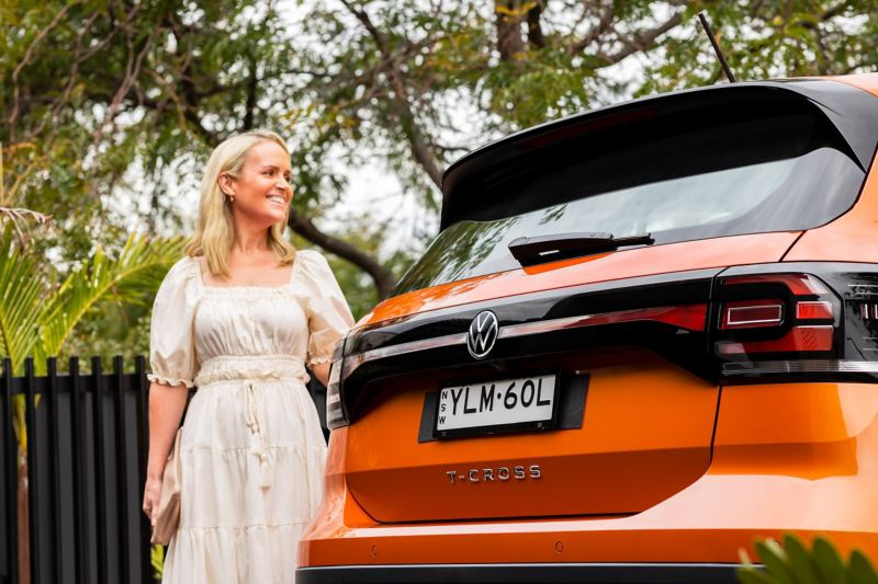 Woman standing next to the Boot door of the Volkswagen T-Cross.