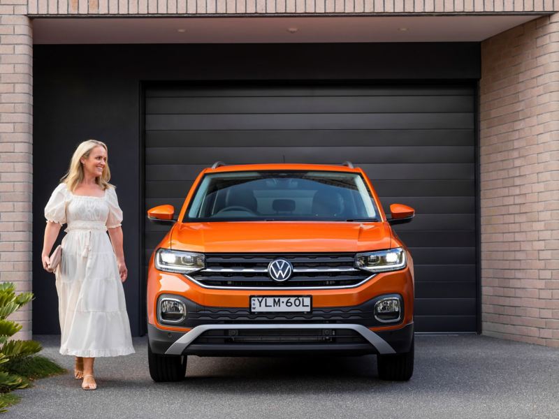 Woman standing next to Volkswagen T-Cross.