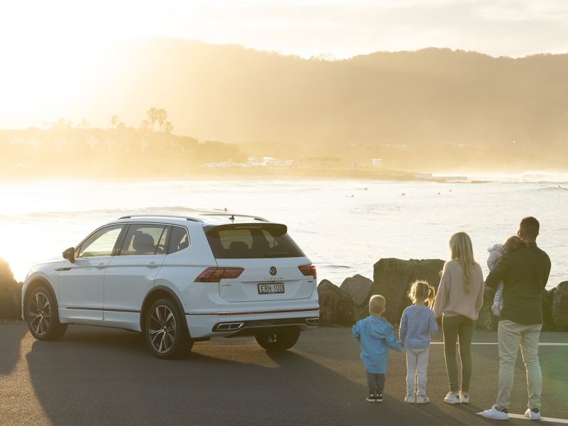 Family watching the sunset in front of a Tiguan Allspace parked