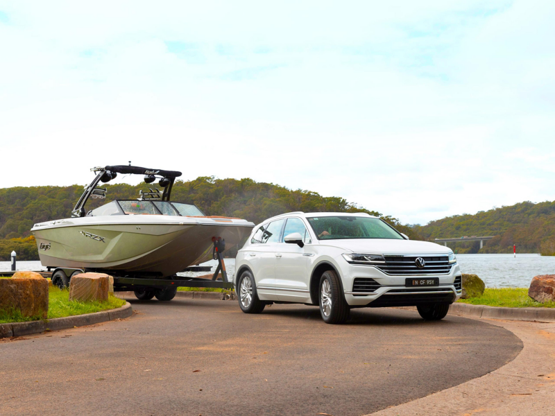 Volkswagen SUV Towing a small boat by the water