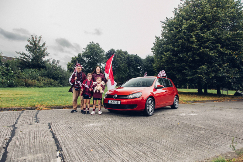 Family stand in front of a red Mk6 VW Golf