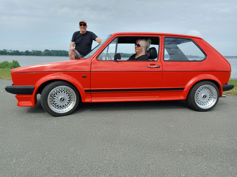 En kvinde sidder i en rød golf gti fra nutiden