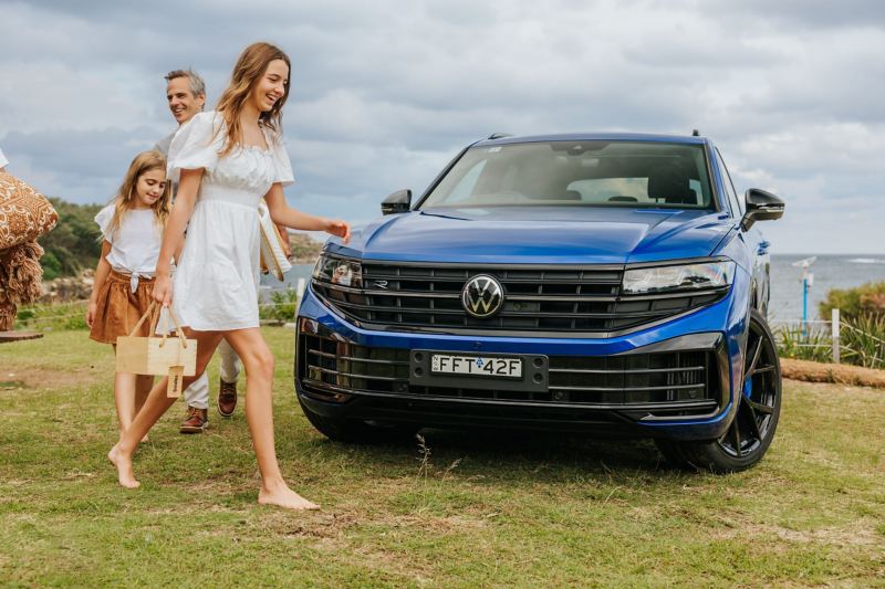 Family picnic with Volkswagen Touareg R eHybrid parked by the beach